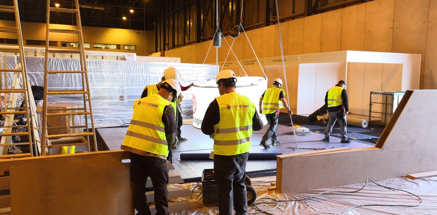 Booth setup and dismantling service showing a professional team assembling and disassembling exhibition stands at a trade show, including detailed organization, efficient equipment handling, and meticulous attention to detail.